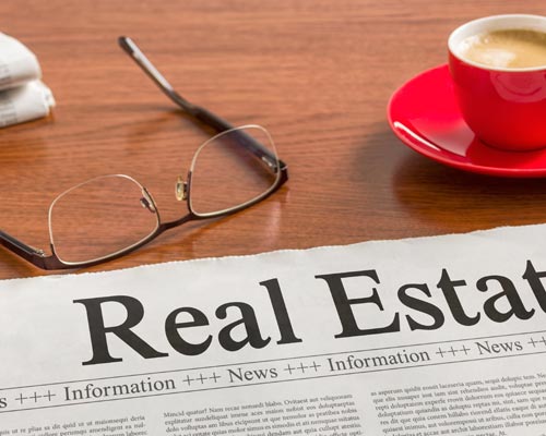 Real estate newspaper with glasses in front